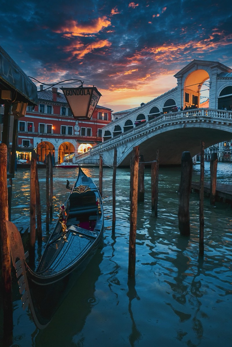 Gondola moored beneath the Rialto Bridge at dusk